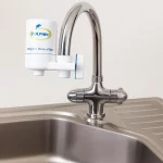 "فیلتر تصفیه آب شیر دلفین نصبشده روی شیر آشپزخانه با طراحی مدرن و بدنه سفید برند DOLPHIN"