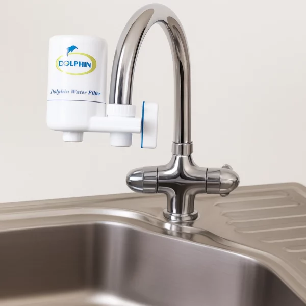 "فیلتر تصفیه آب شیر دلفین نصب‌شده روی شیر آشپزخانه با طراحی مدرن و بدنه سفید برند DOLPHIN"